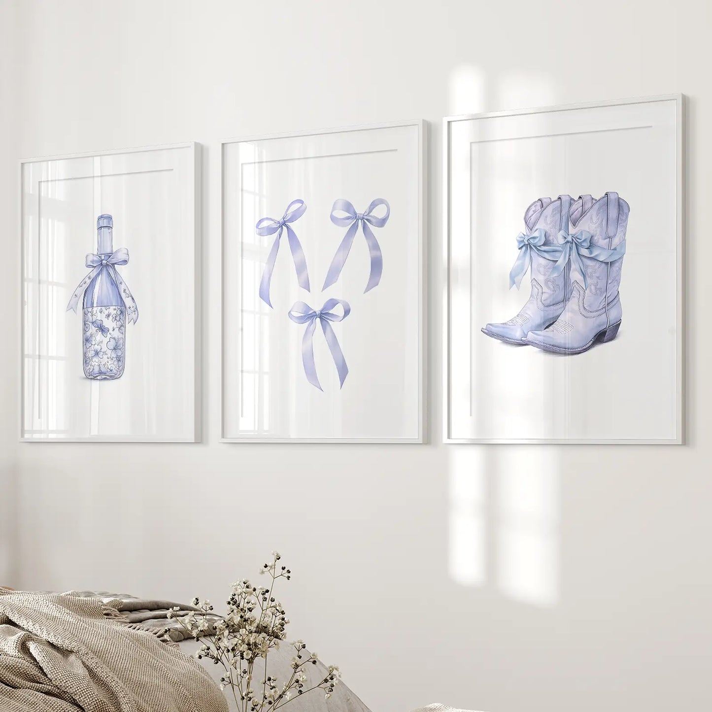 Pastel blue cowboy boot print set with floral details and ribbon bow artwork. White frames with mat above the bed.
