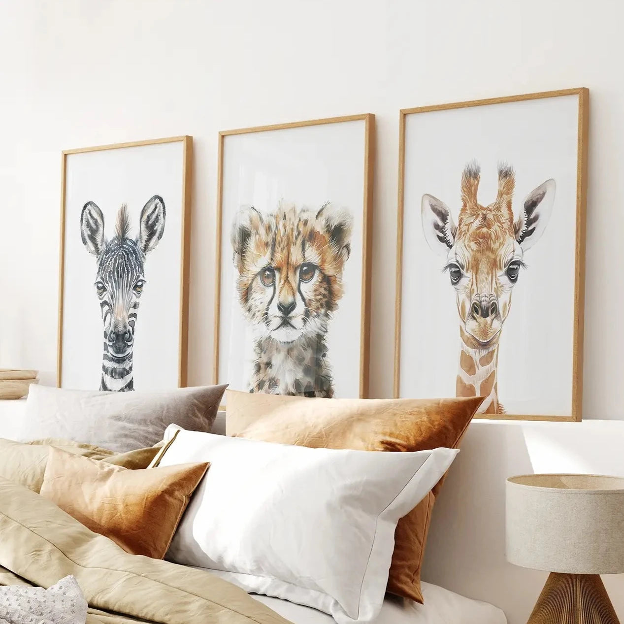 Safari animal nursery wall art set of 3 with zebra, cheetah, and giraffe prints. Thinwood frames over the bed.