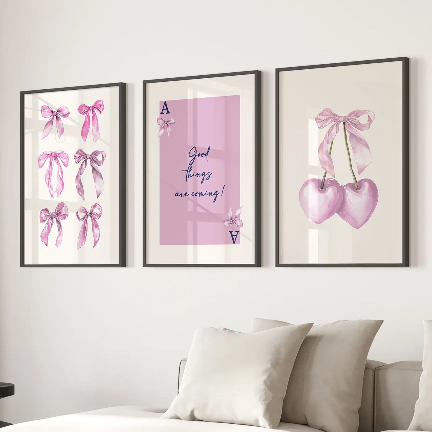 Elegant pink girly decor prints with bows, cherries, and positive quote for wall gallery. Black frames above the sofa.