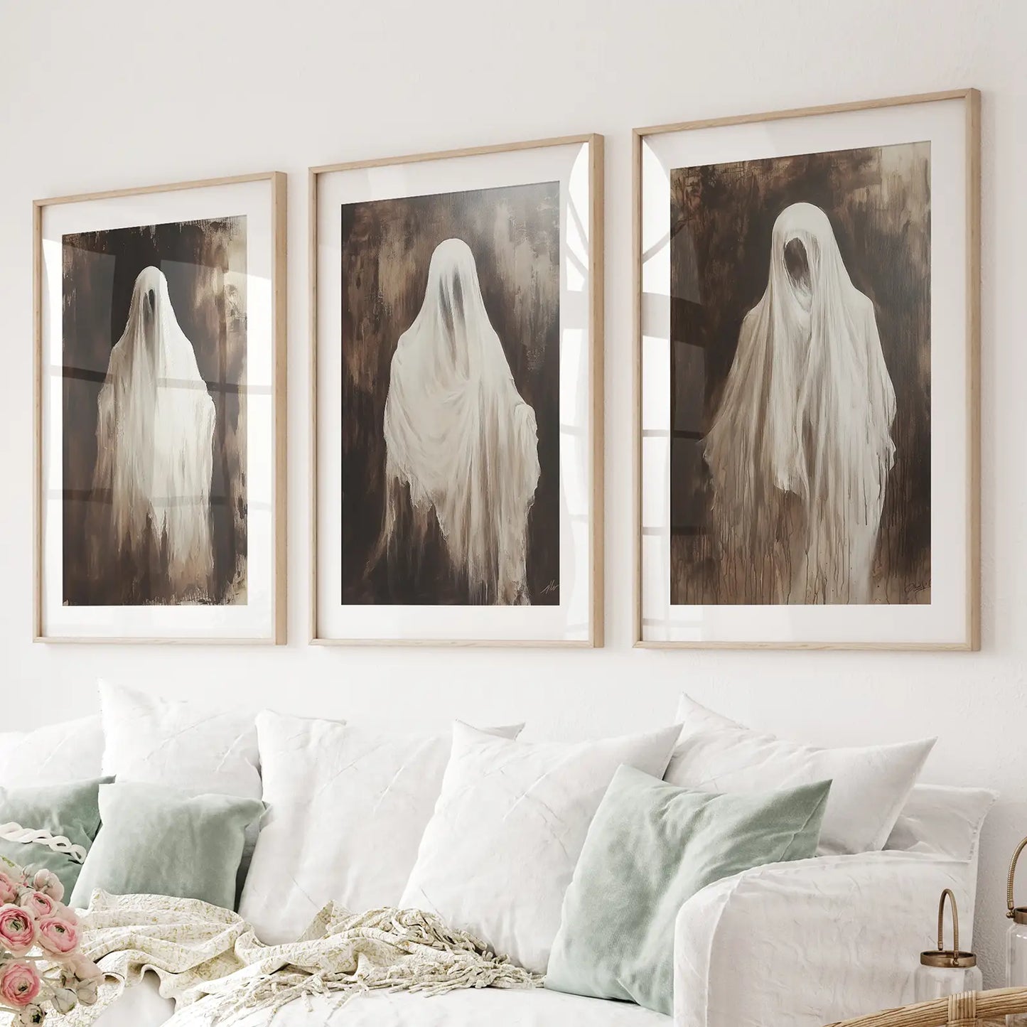 Set of 3 ghost prints with eerie spirits in flowing white sheets. Thinwood frames with mat over the couch.