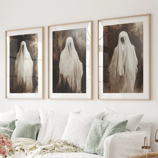 Set of 3 ghost prints with eerie spirits in flowing white sheets. Thinwood frames with mat over the couch.
