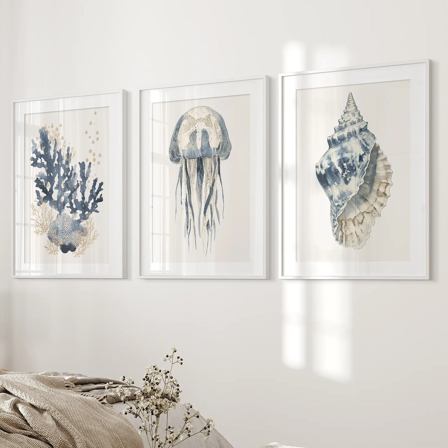 Blue home decor contemporary artwork. Set of 3 sea life. White frames with mat over the bed.
