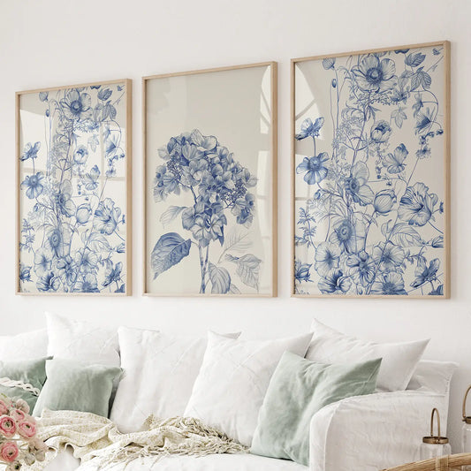 Blue botanical wall art set of 3 prints with hydrangea and wildflowers.Thinwood frames above the sofa.