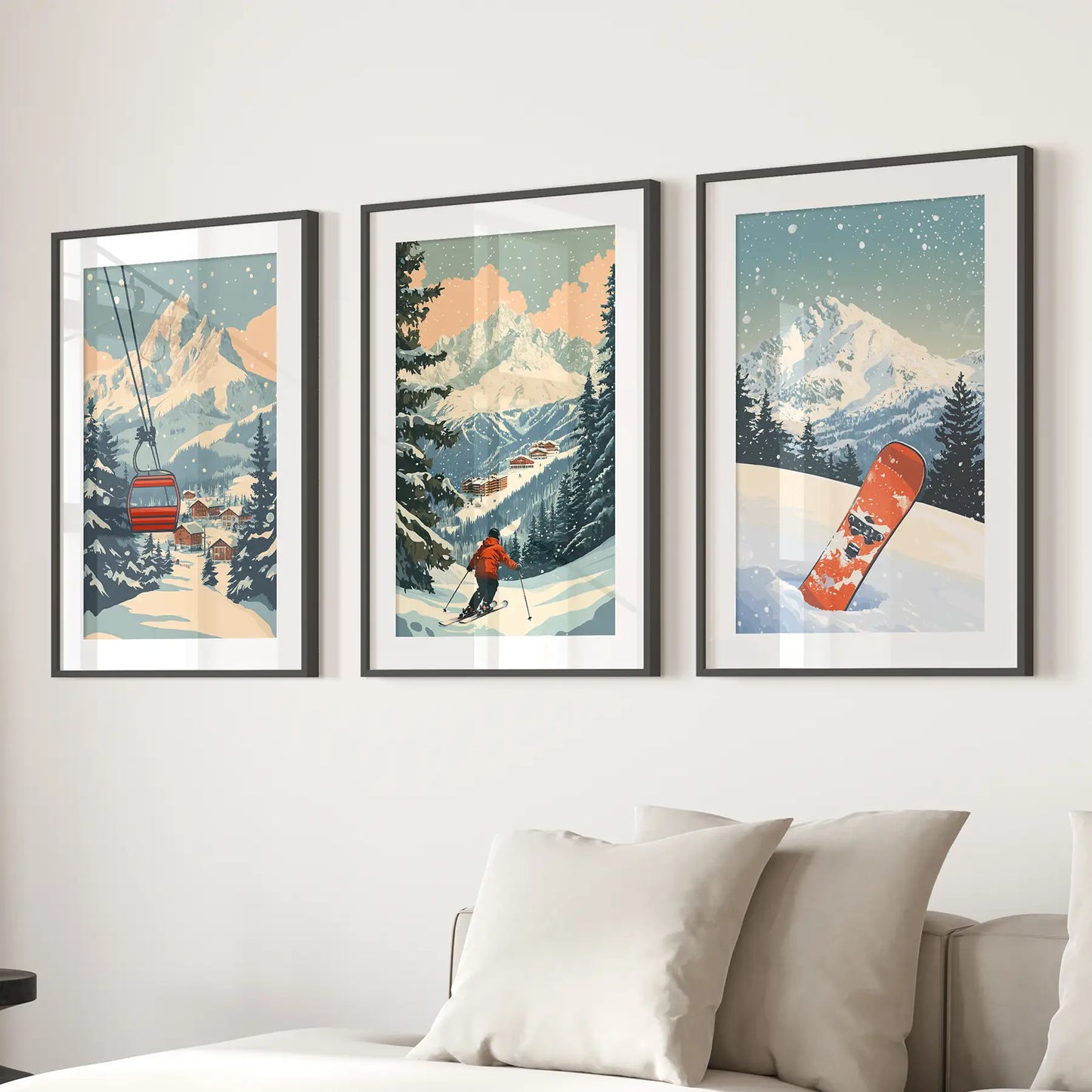 Vintage ski posters. 3 piece wall art depicting winter scenes with mountains, a ski lift, and a snowboard on a wall above a sofa. Black frames with mat