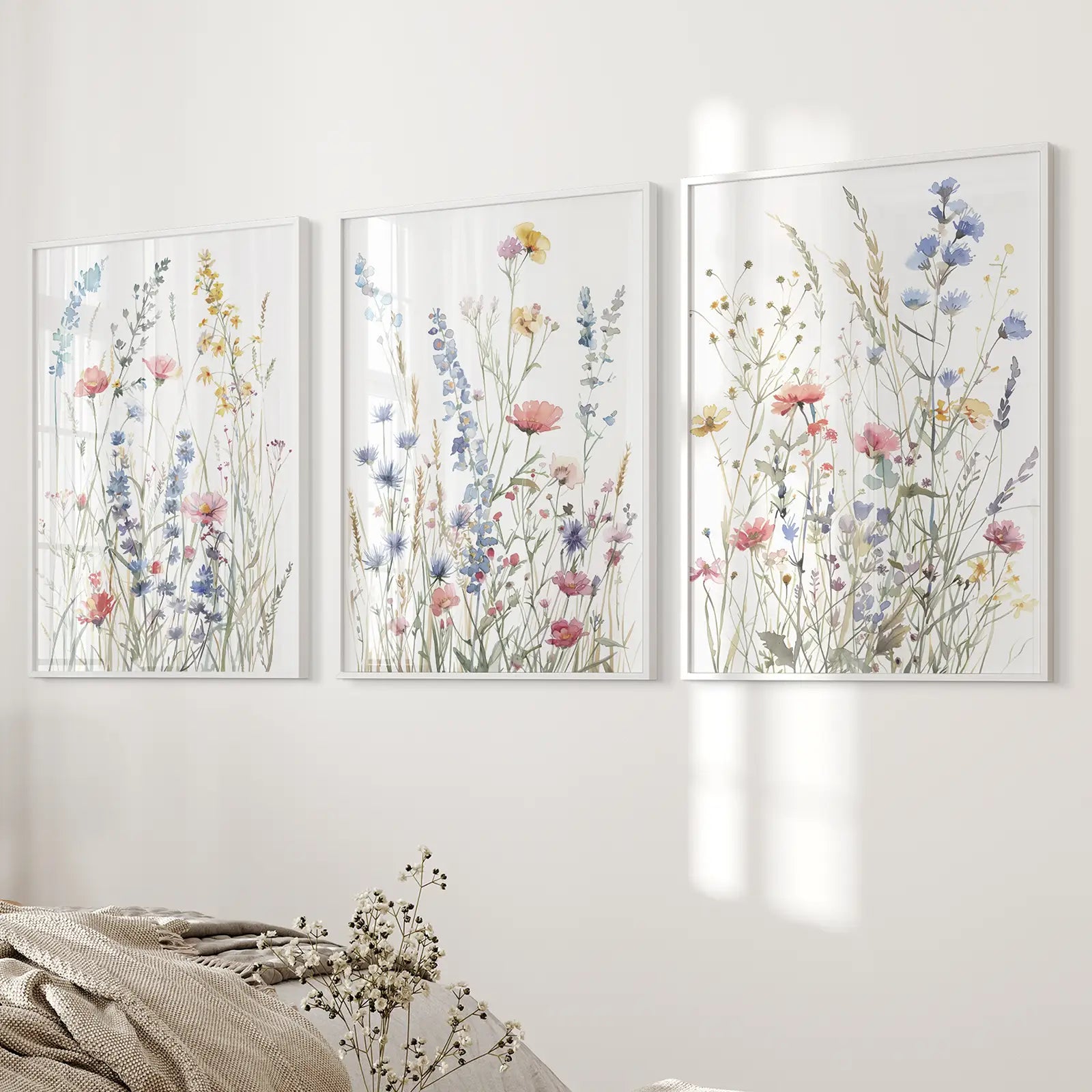 Pastel meadow flowers watercolor prints set of 3. White frames above the bed.