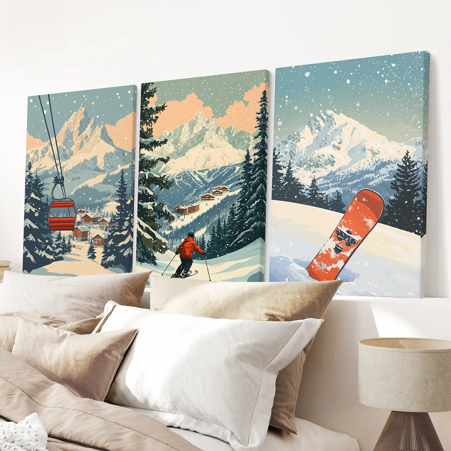 Three ski-themed canvas prints above a bed. Mountains, pines, snowboard, and ski lift