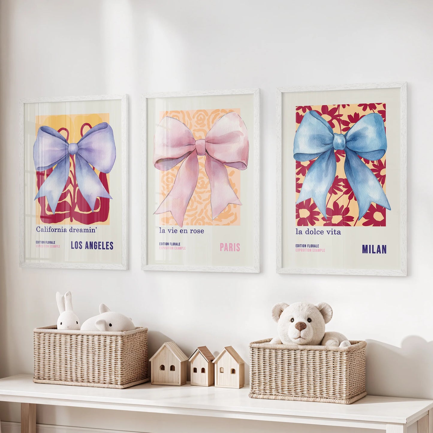 Three white-framed poster prints of watercolor bows bring gentle motion and pastel warmth to the kids’ room walls.