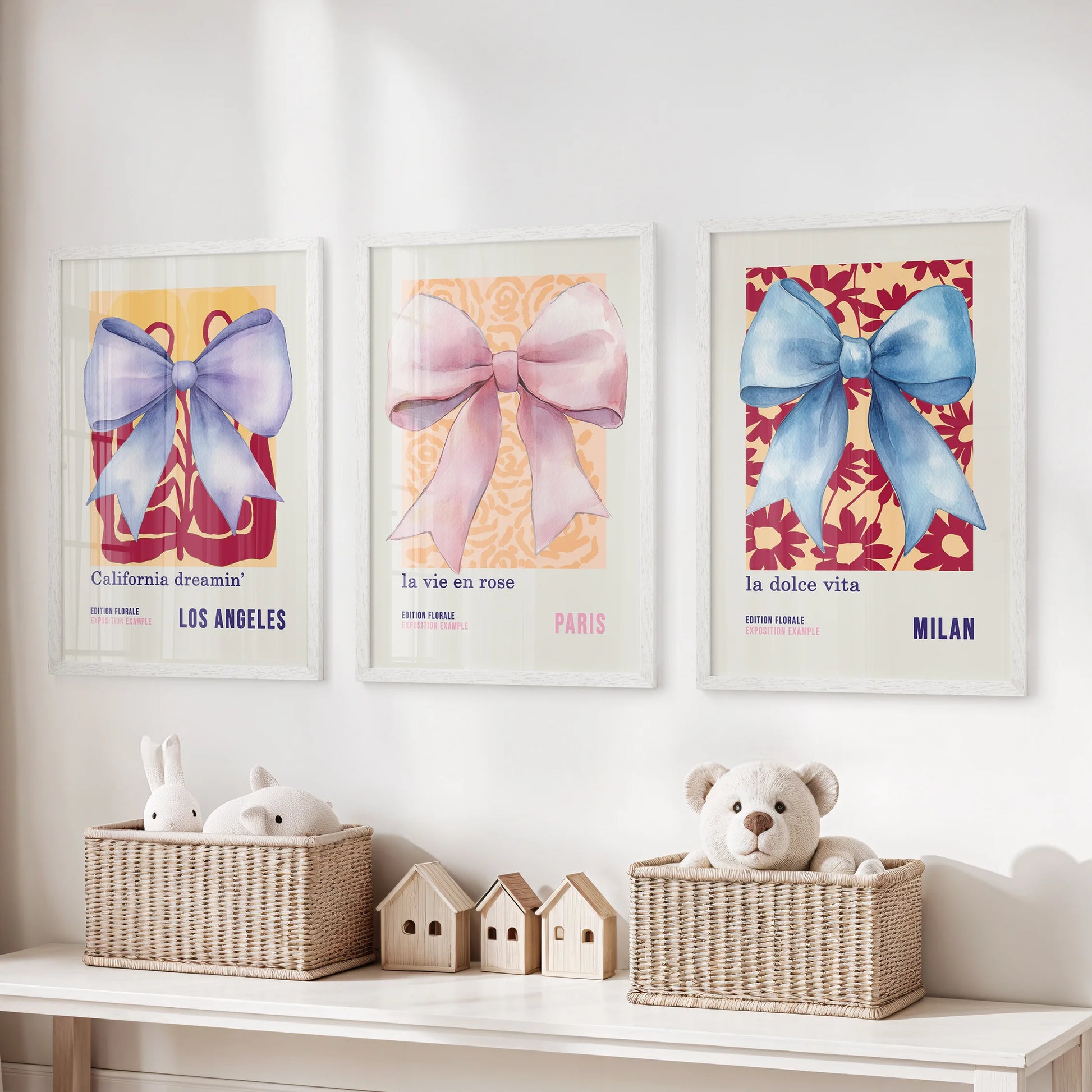 Three white-framed poster prints of watercolor bows bring gentle motion and pastel warmth to the kids’ room walls.