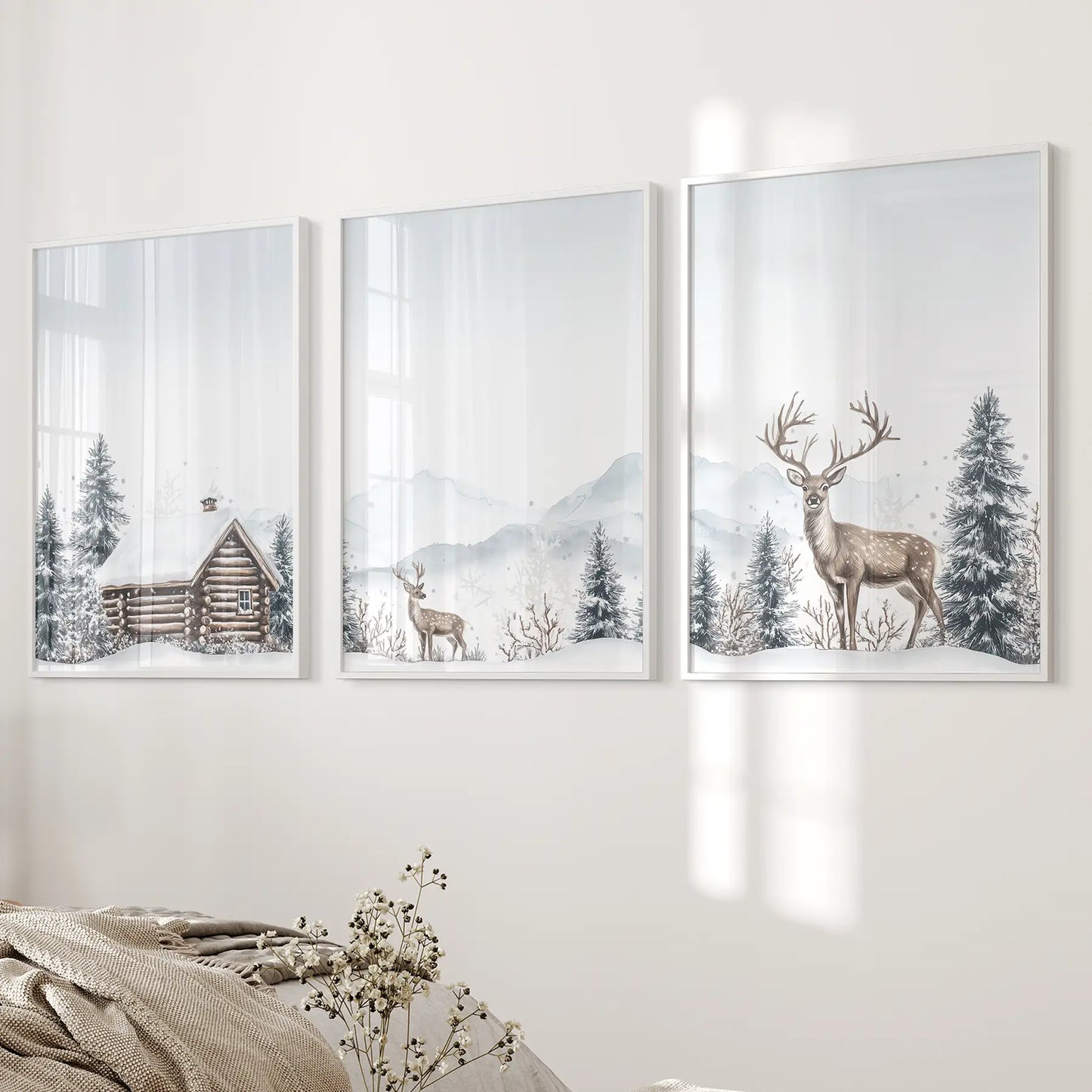 Farmhouse winter wall art with cabin and reindeer design. White frames over the bed.