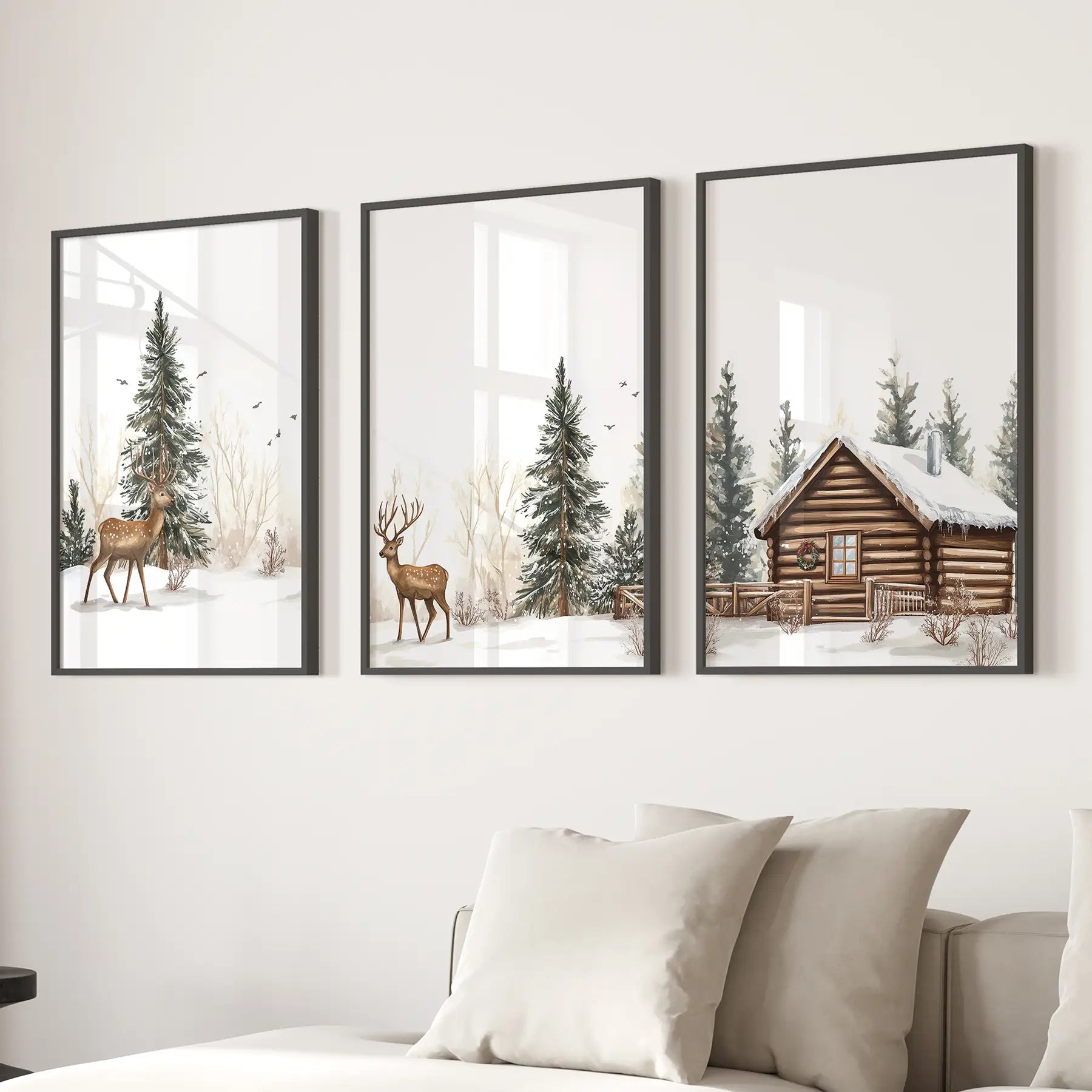 Snowy landscape wall art set – deer in a winter forest with cabin scene. Black frames above the sofa.