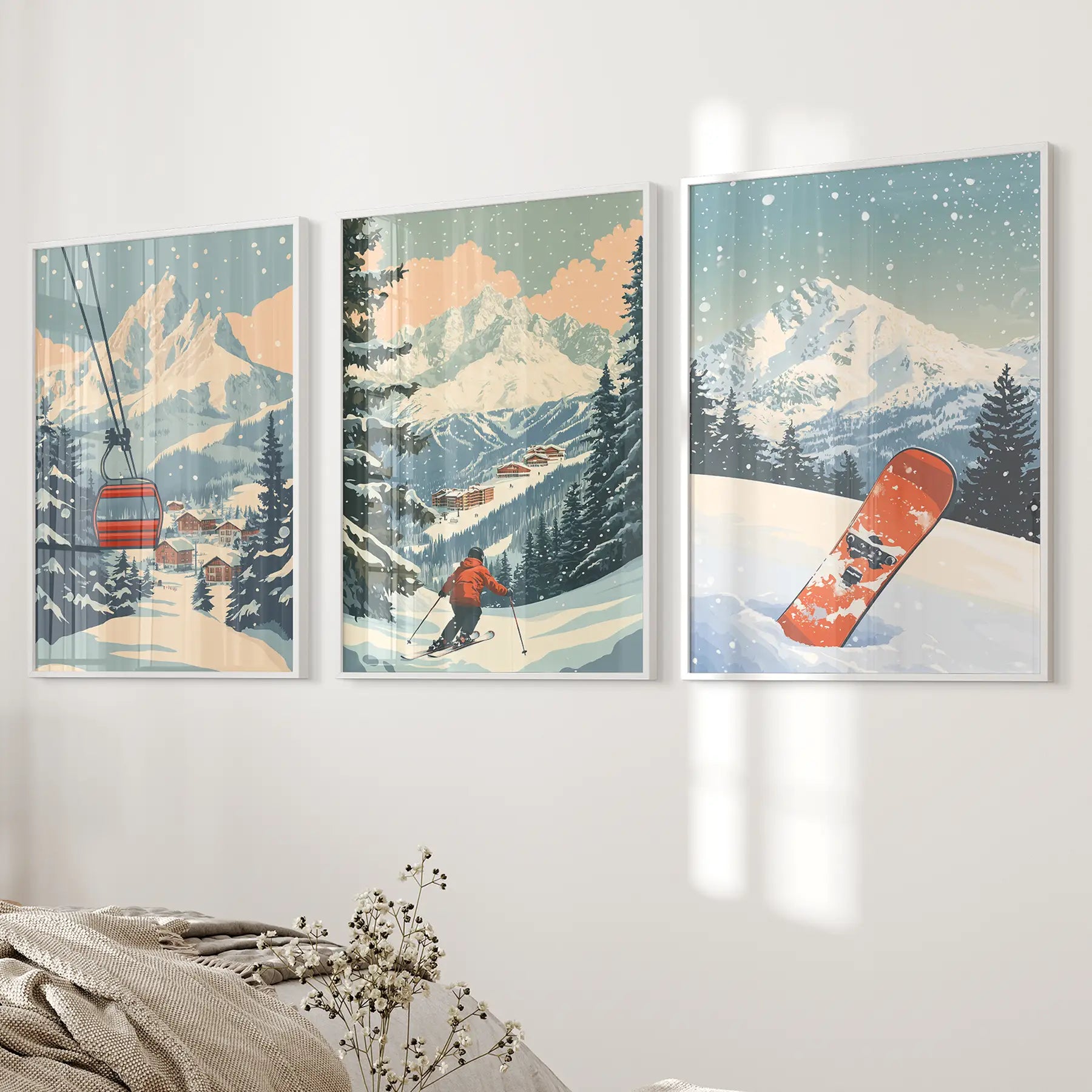 Set of 3 framed artworks depicting ski scenes with mountains, a skier, ski lift, and a snowboard. White frames