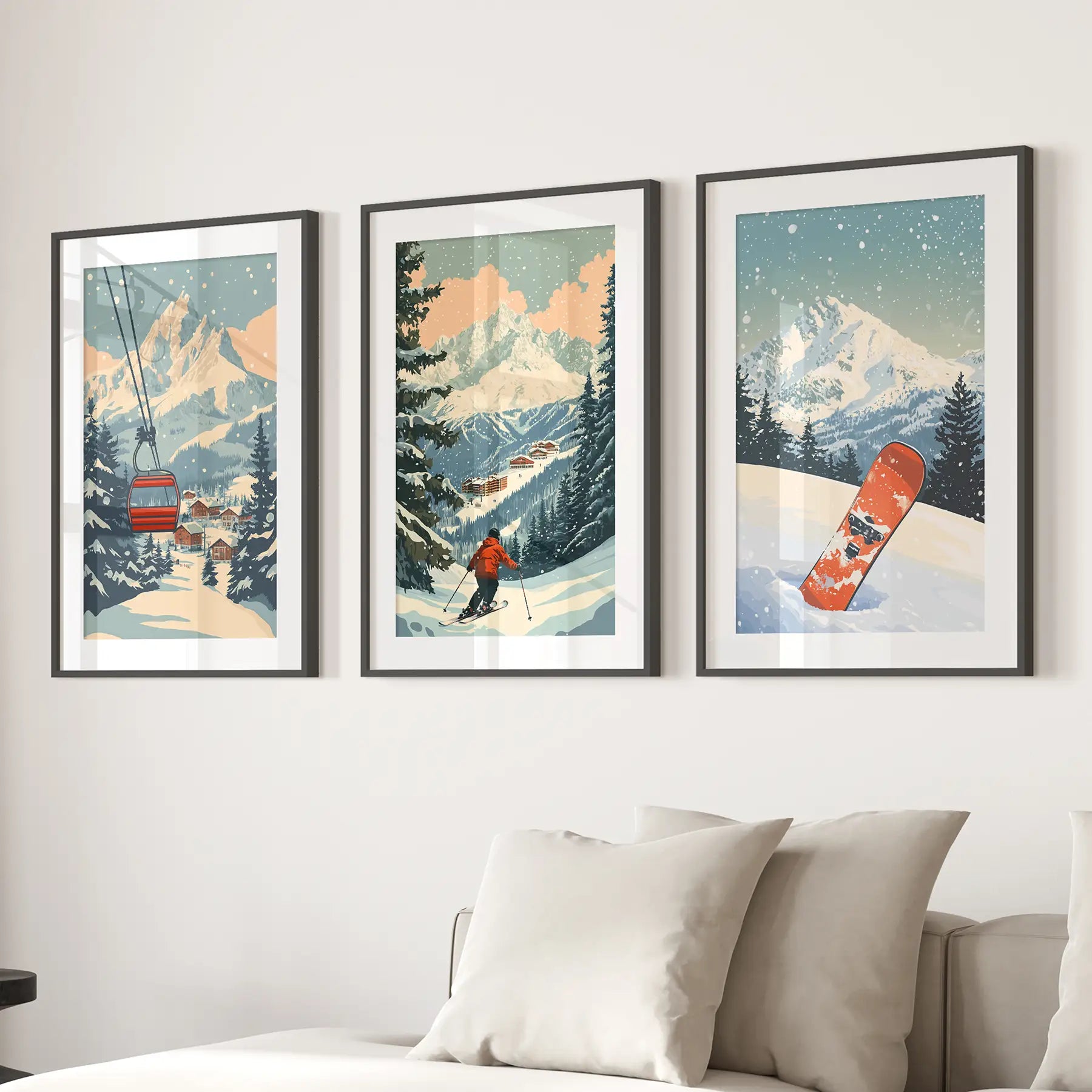 Vintage ski posters. 3 piece wall art depicting winter scenes with mountains, a ski lift, and a snowboard on a wall above a sofa. Black frames with mat