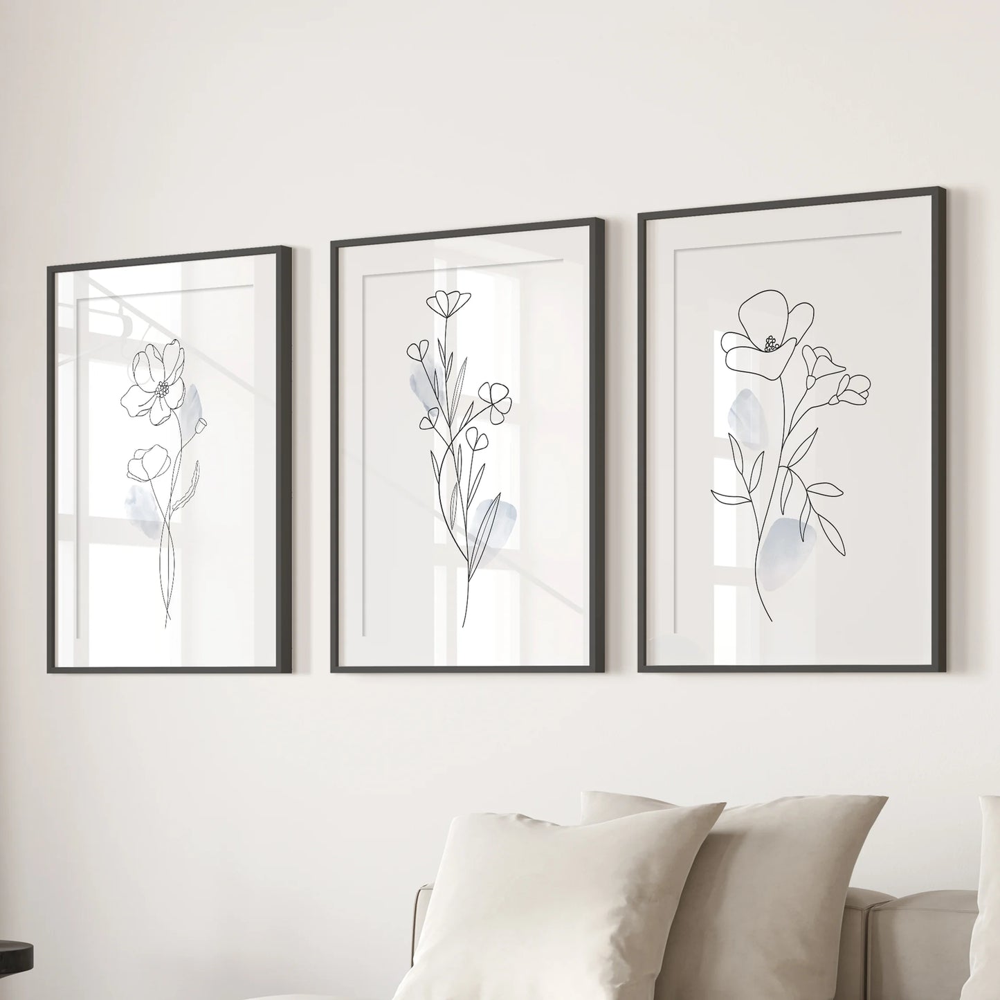 Triple watercolor leaf artworks in black frames with white mats span the family room wall above the sectional for a fresh, natural note.