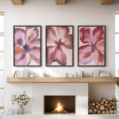 Abstract burgundy and mauve flowers fill three black-framed prints above a fireplace.