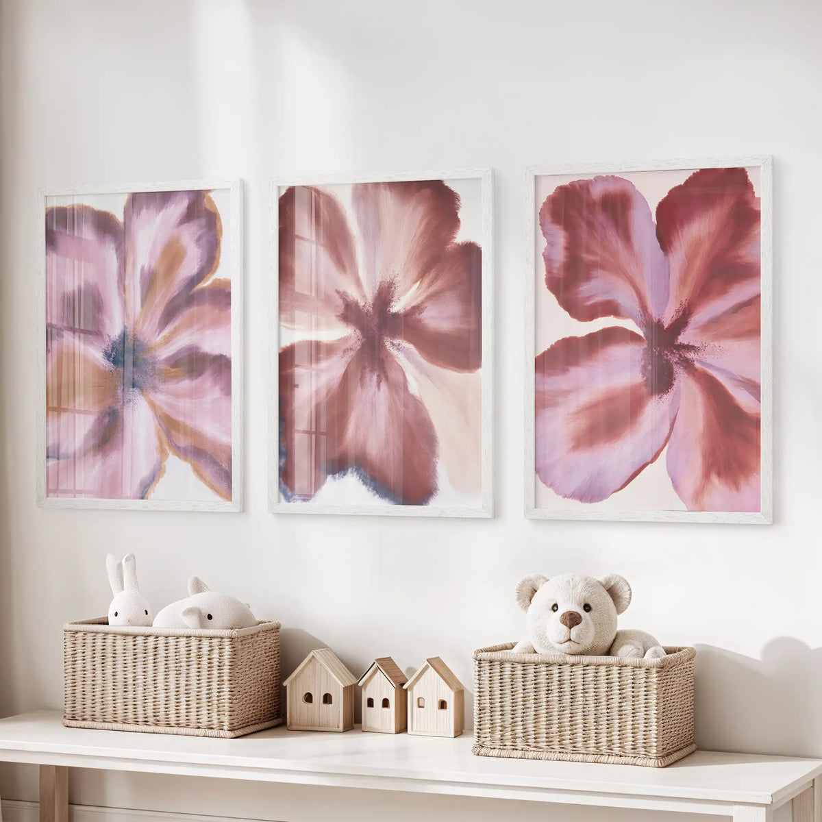 Abstract burgundy flowers fill three white-framed prints above a toy storage bench.