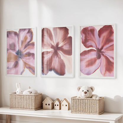 Abstract burgundy flowers fill three white-framed prints above a toy storage bench.