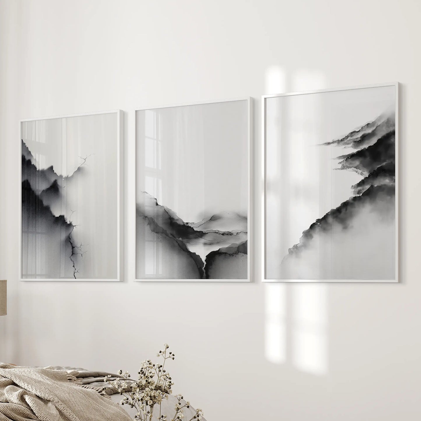 Three-piece wall decor of watercolor landscapes in crisp white frames quietly brightens the bedroom wall near the bed.