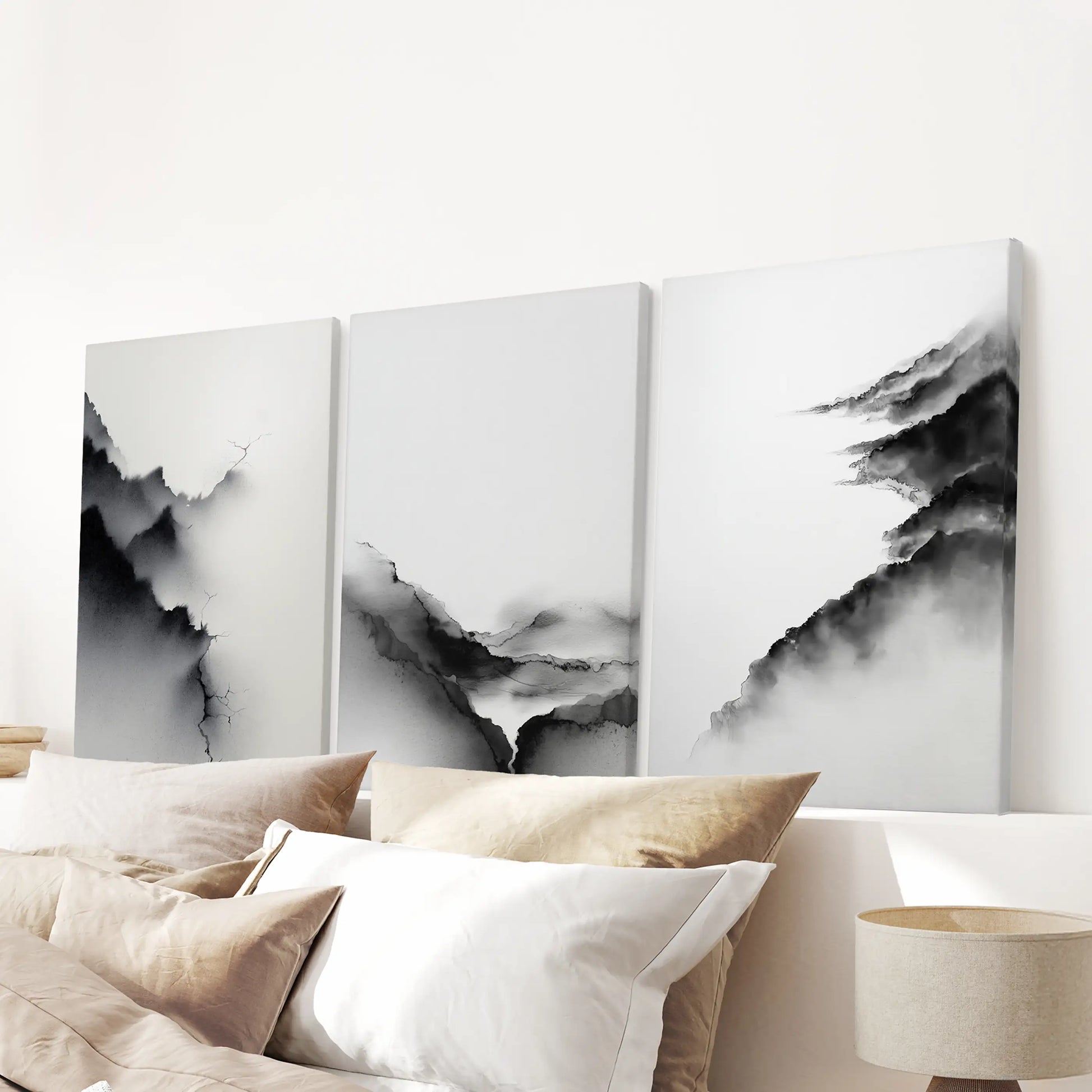 A set of three canvas wall prints with minimalist mountain shapes aligns above the headboard, keeping the bedroom serene and tidy.