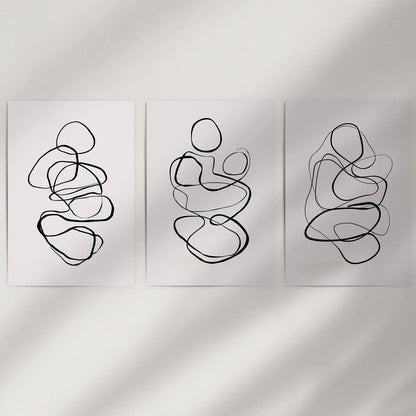 Minimalist contour art in a three-part poster set fills blank wall space; unframed prints keep the look light and easy to mix.