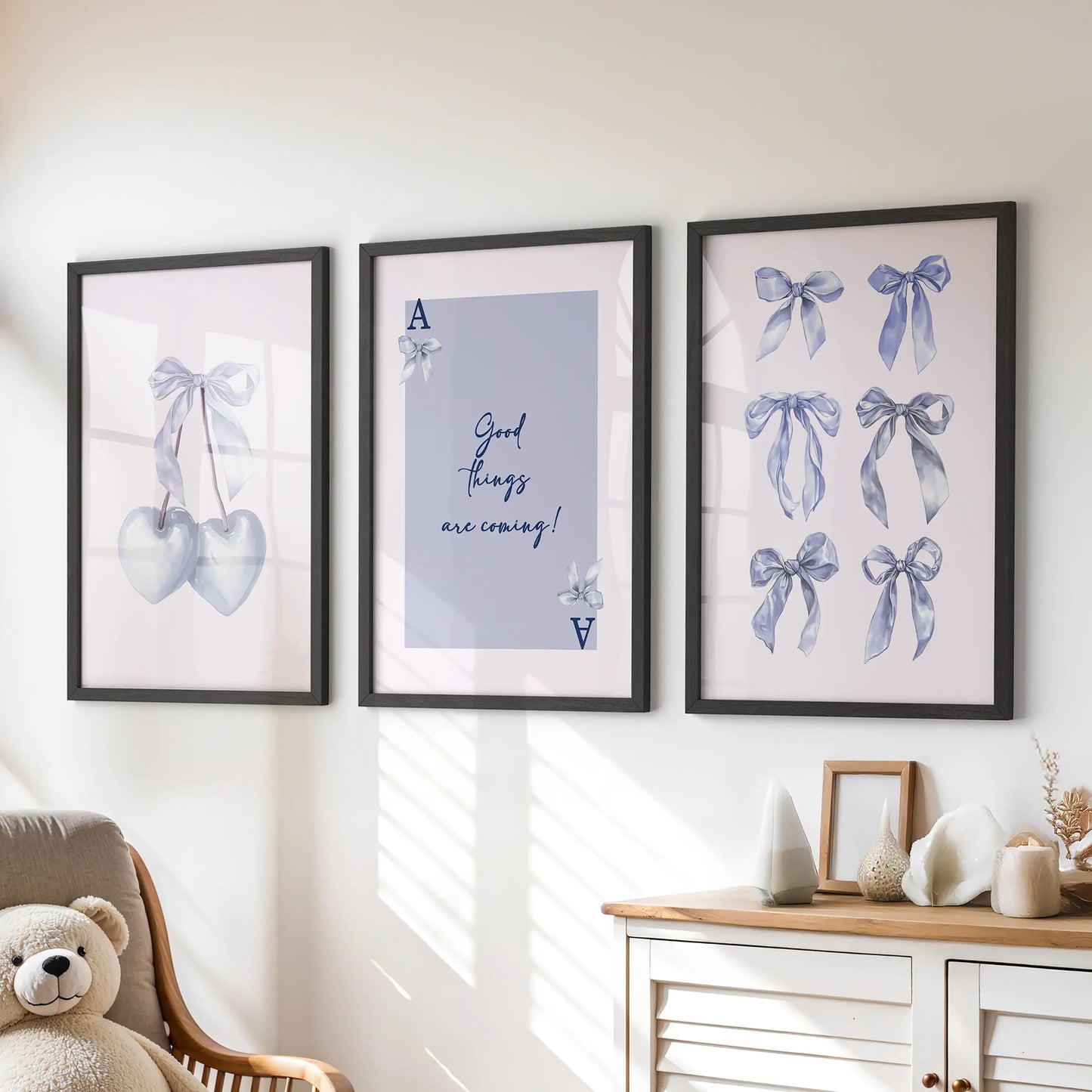 Heart-card motif wall prints, a playful trio in black frames, sit above the playroom dresser bringing tidy pops of soft blue charm.