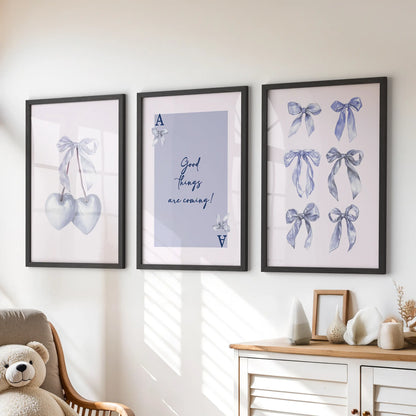 Heart-card motif wall prints, a playful trio in black frames, sit above the playroom dresser bringing tidy pops of soft blue charm.