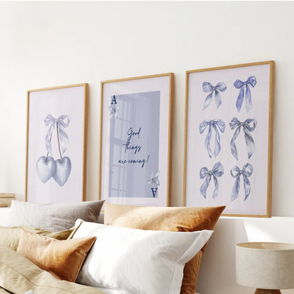 Heart suit card motif wall art, trio set, in warm wood frames hangs over the bed headboard, blending soft blue graphics with cozy bedroom texture.