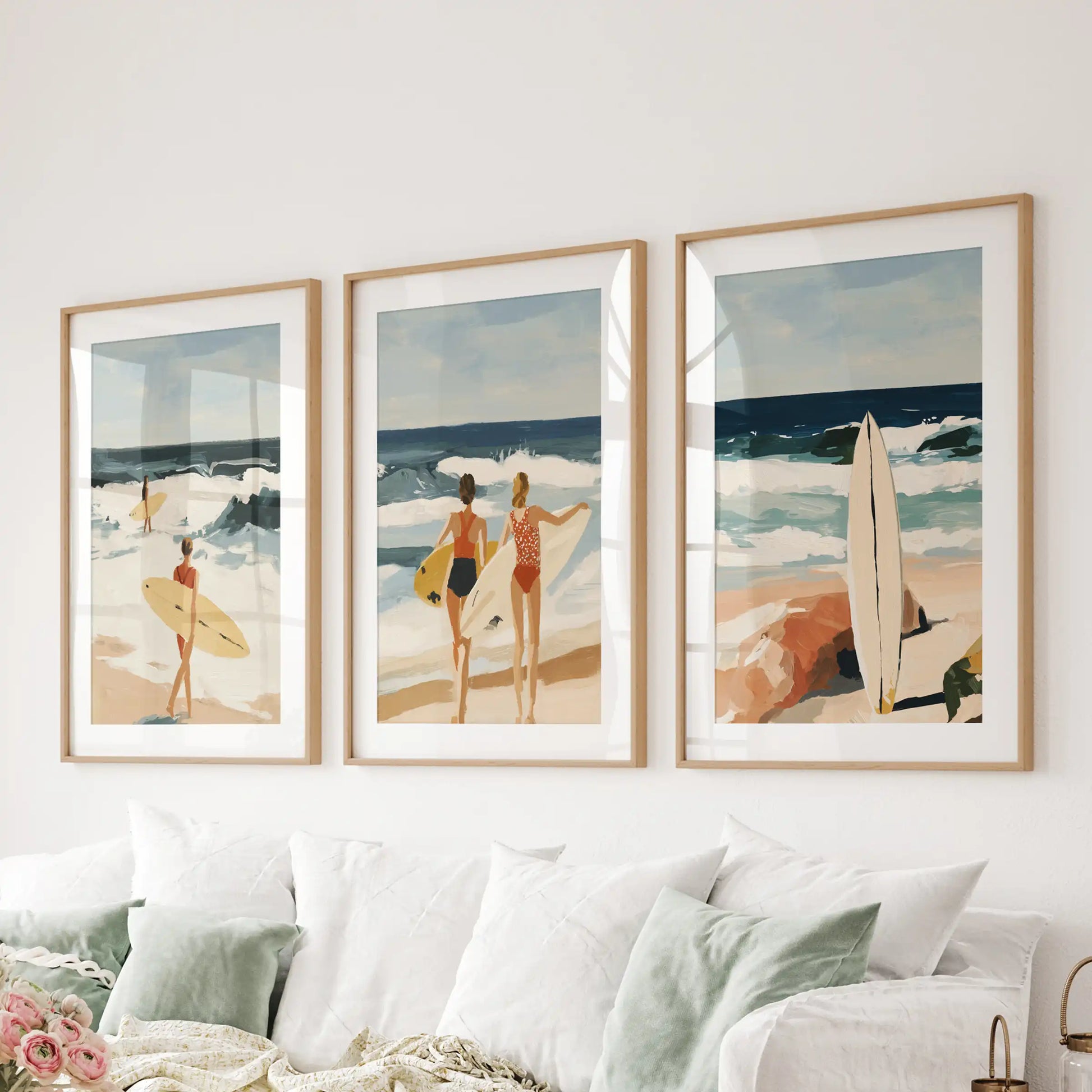 Coastal beach scenes set of three wall decor, in light wood matted frames, spans the sitting room wall above the couch with sunlit shoreline calm.