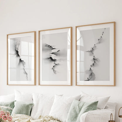 An artful set of three wood-framed abstract prints with mats stretches behind the couch, refining the sitting room’s modern tone.
