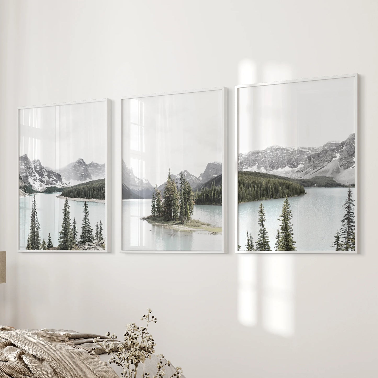 Maligne Lake panorama, print set of 3 in slim white frames, rests along the bedroom wall beside the bed to keep the view serene and uncluttered.
