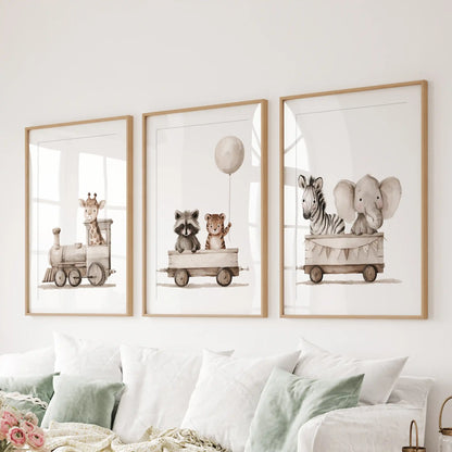 A set of three animal train prints in oak frames with white mats above a sofa.