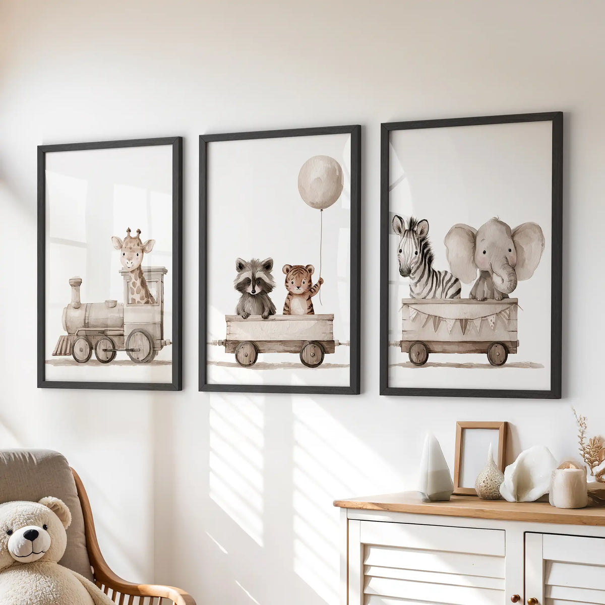 Black frames hold three animal train prints above a dresser in a child's room.