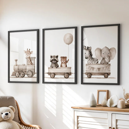 Black frames hold three animal train prints above a dresser in a child's room.