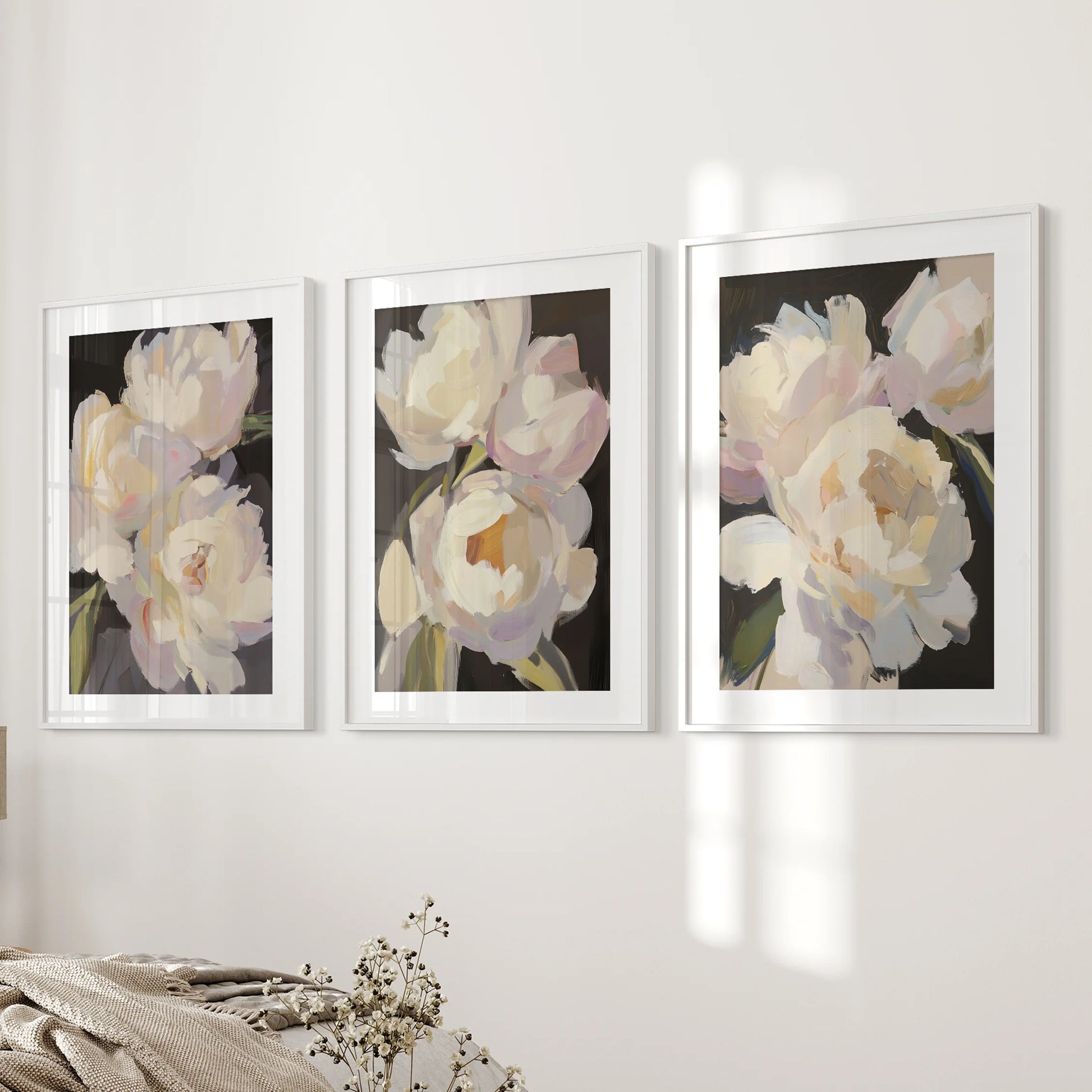 Moody dark florals in a print trio set rest on the bedroom bedside wall in white matted frames, balancing drama with soft blush petals.