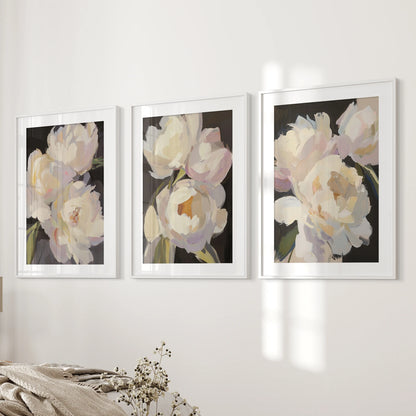 Moody dark florals in a print trio set rest on the bedroom bedside wall in white matted frames, balancing drama with soft blush petals.