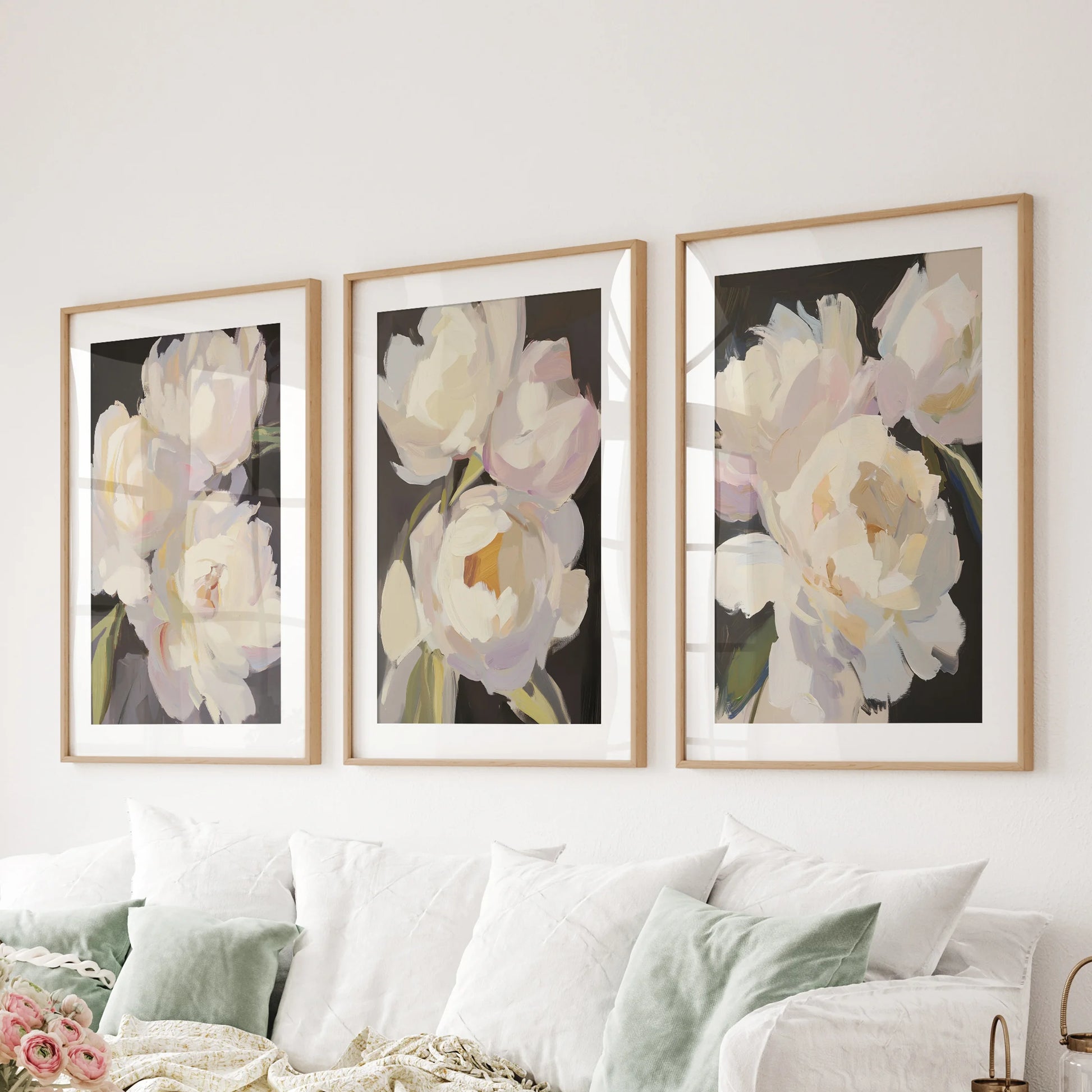 Across the family-room sectional, a set of three peony prints in thin wood frames with mats offers a refined yet comfortably aged look.