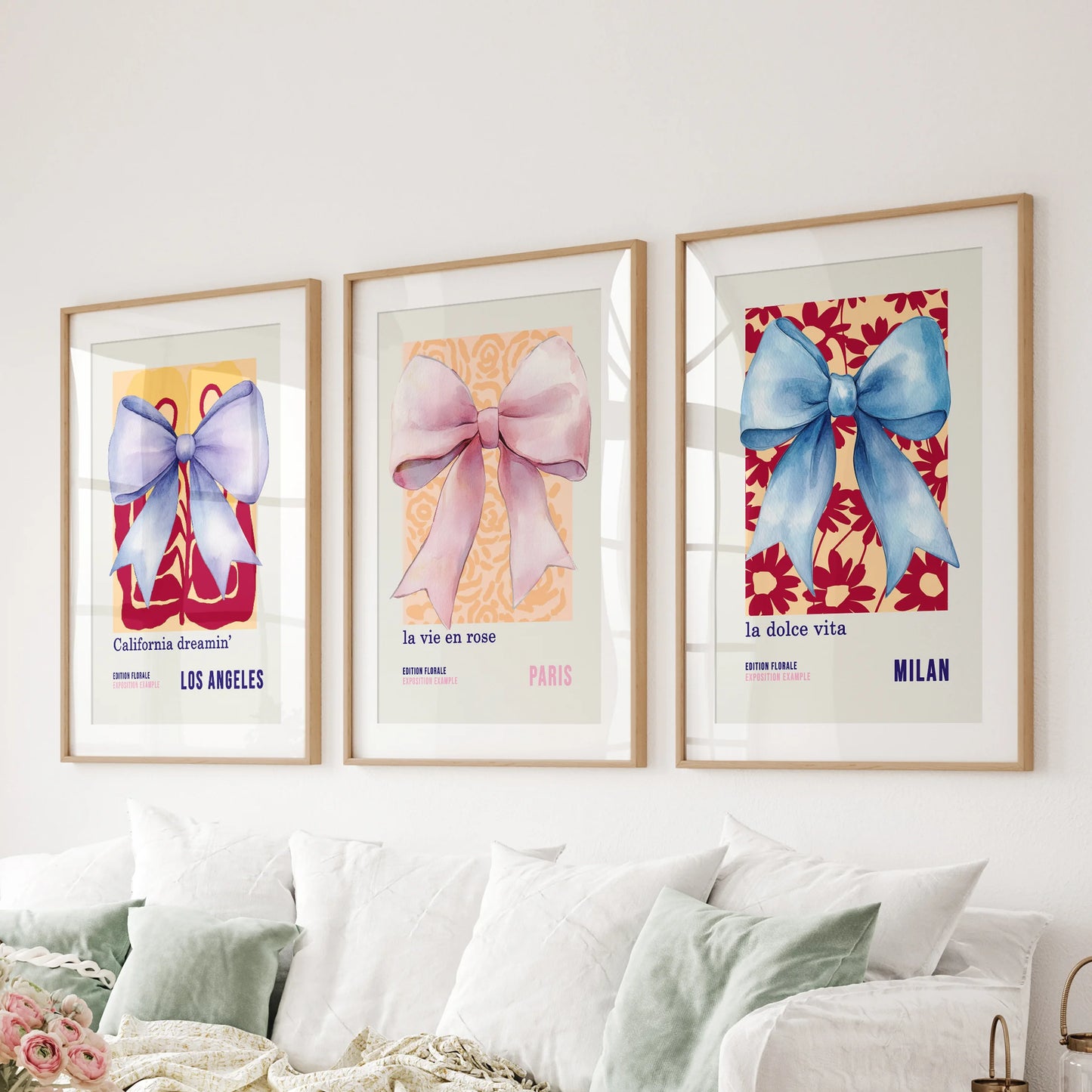 Three watercolor bow prints, matted and framed in solid oak, hang over the living room couch for an airy, preppy layout.