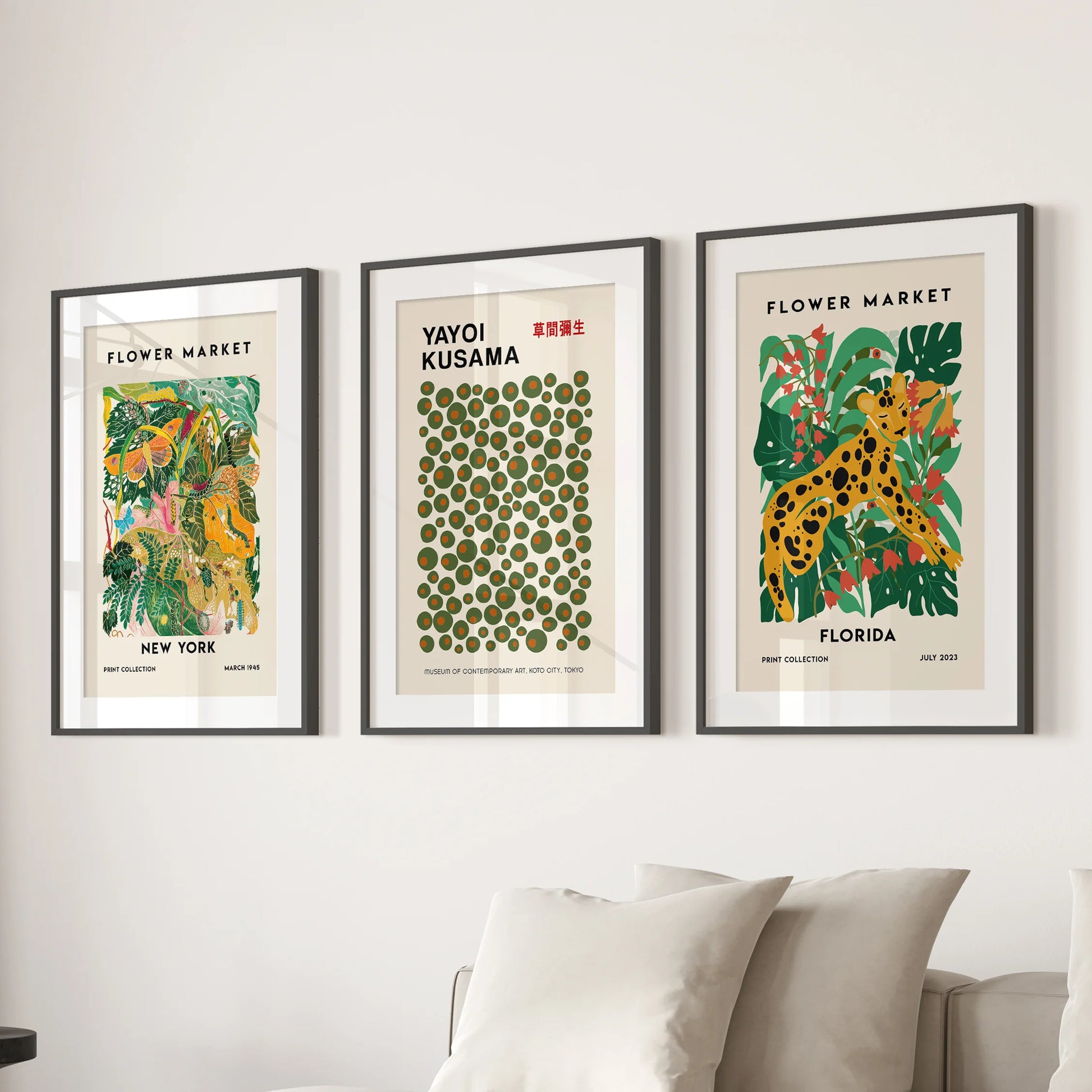 Colorful triptych exhibition posters, a three-panel wall set, bring modern polish over the sitting room couch in black frames with crisp white mats.