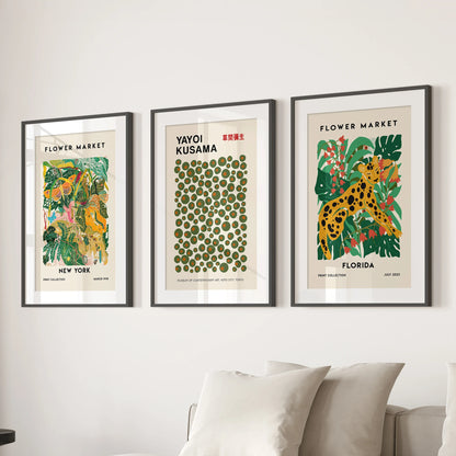 Colorful triptych exhibition posters, a three-panel wall set, bring modern polish over the sitting room couch in black frames with crisp white mats.