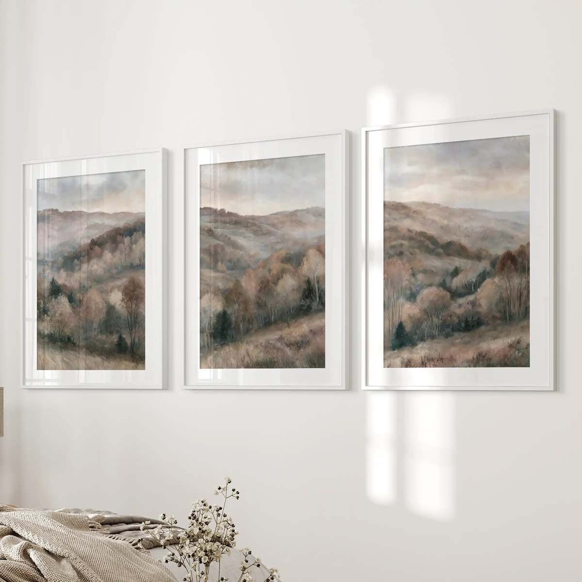 Autumn forest landscape art prints, a set of 3, line the bedroom wall beside the bed in white-matted frames for a cozy, balanced focal point.