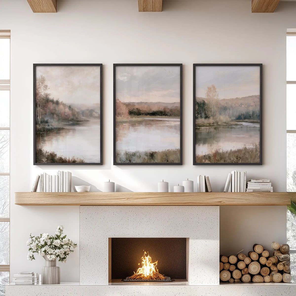 A three-piece wall art set of autumn lake landscapes hangs in black frames over the living room mantel, with soft, neutral fall tones.