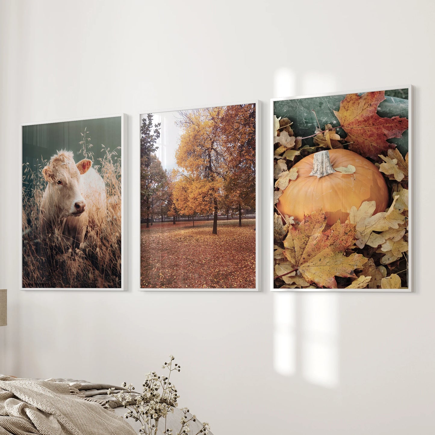 A white-framed trio of forest landscape prints hangs near the bedroom bed wall, adding a calm woodland mood.