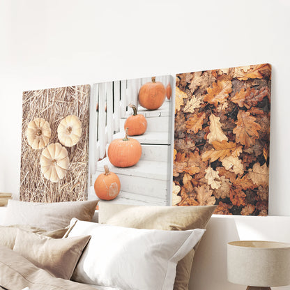 Stretched canvas triptych of farmhouse pumpkins hangs above the bed, casting warm, rustic autumn tones across the bedroom wall.