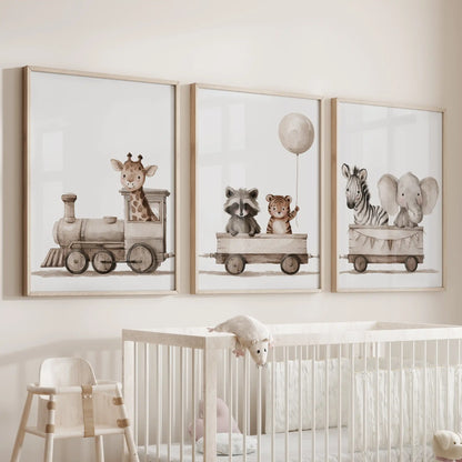 The middle of three oak-framed prints above a crib shows a raccoon and tiger beneath a balloon; a giraffe leads the train at left.