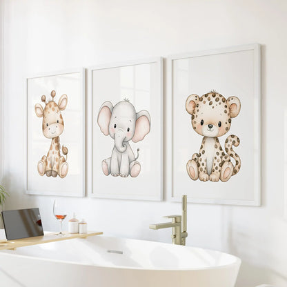 Above a freestanding bathtub, white frames surround three prints of a baby giraffe, elephant and spotted leopard.
