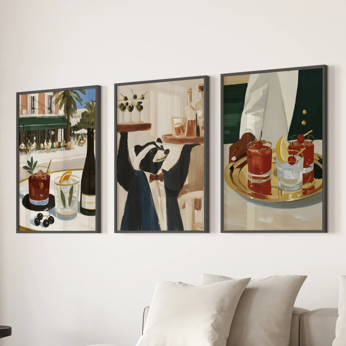 Three-poster wall art set featuring bar cart artwork, shown in black frames over a sectional in the lounge.