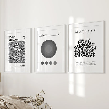 Bauhaus geometric posters, gallery of three, sit near the bed wall in the bedroom, set in white frames with matting for a refined, balanced spread.