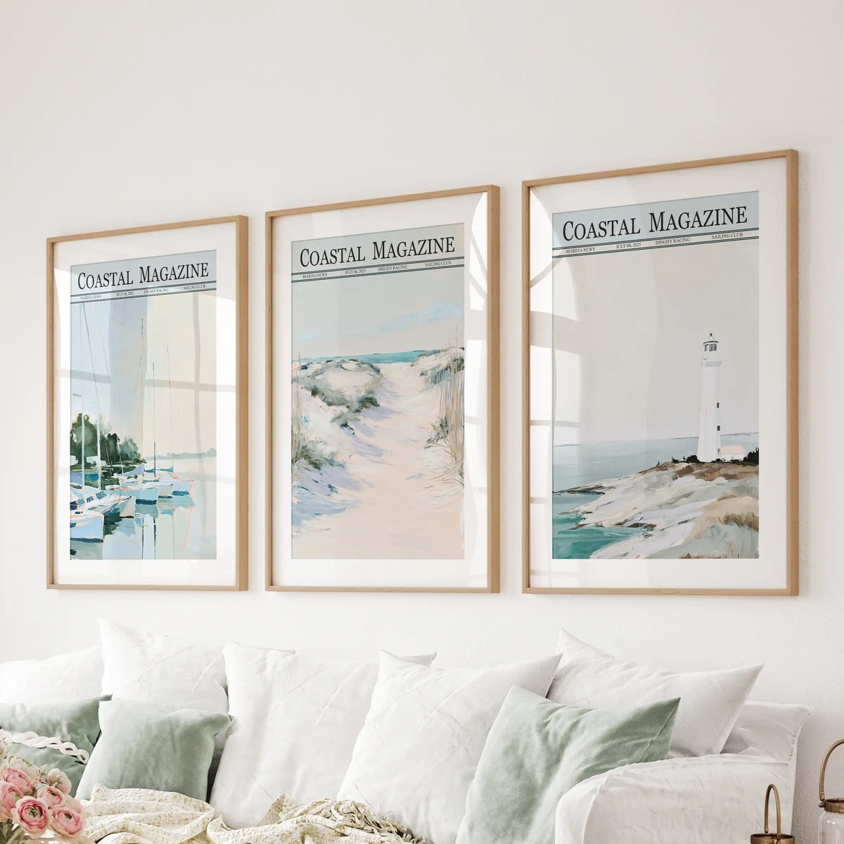 Coastal scenery 3-print wall art set in matted wood frames, displayed behind a sofa in a lounge with sailboat, dune and lighthouse views.