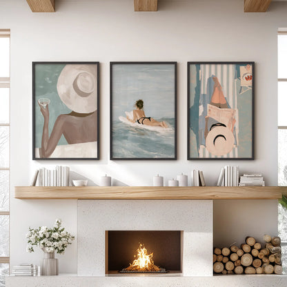 Beach girl wall art set of three in black frames, hanging above the mantel in a sitting room.
