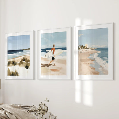 A trio of white-matted surfer prints refreshes the bedside wall, giving the bedroom soft coastal color and breezy movement.