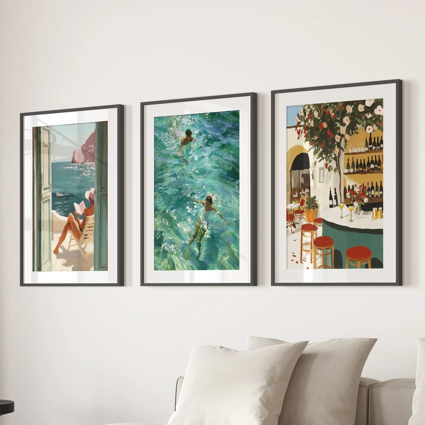 A trio of seaside café wall prints hangs behind the couch, each in a black-matted frame for a relaxed Mediterranean gallery feel.